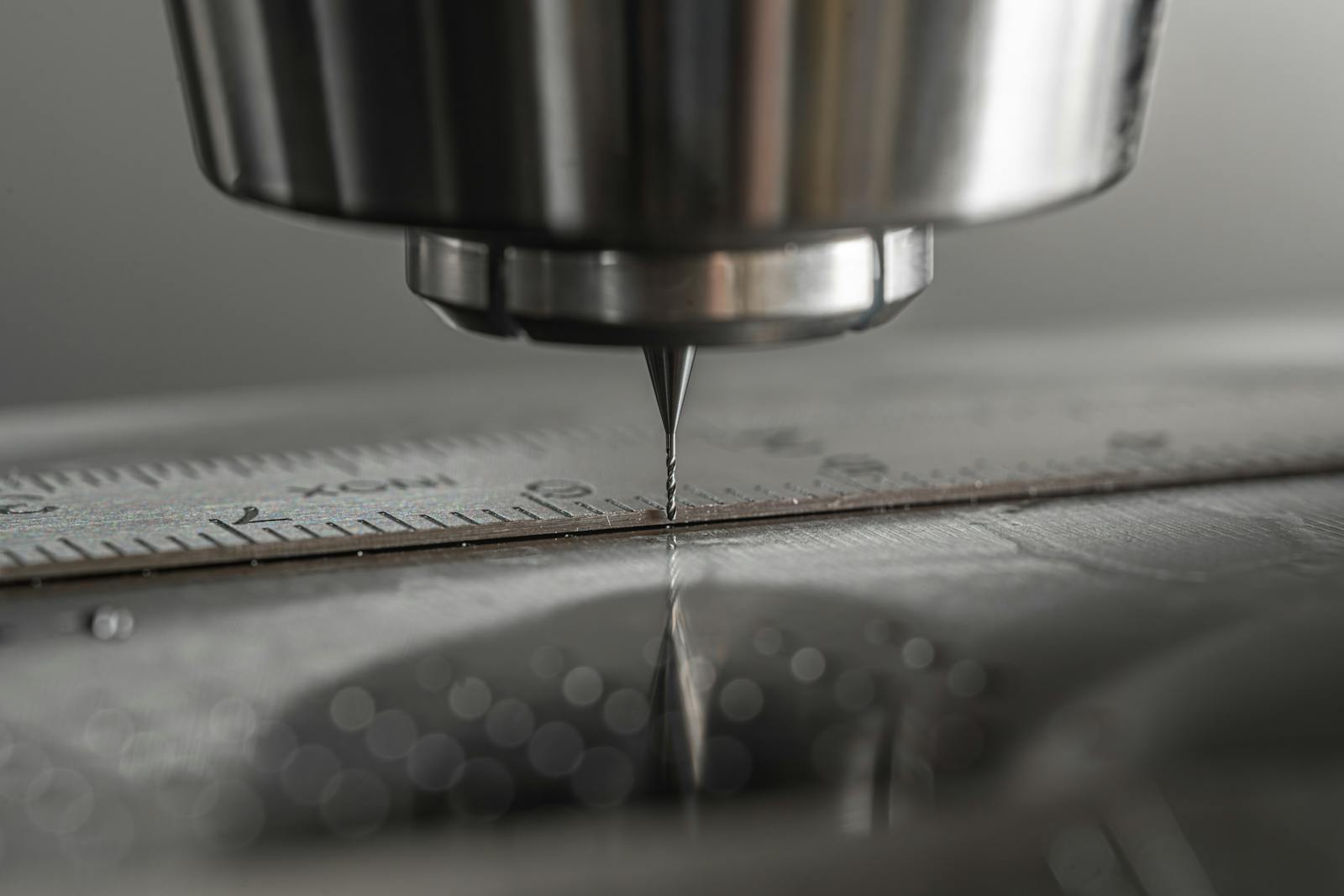 CNC milling machine spindle performing precision machining on steel workpiece with tight tolerances